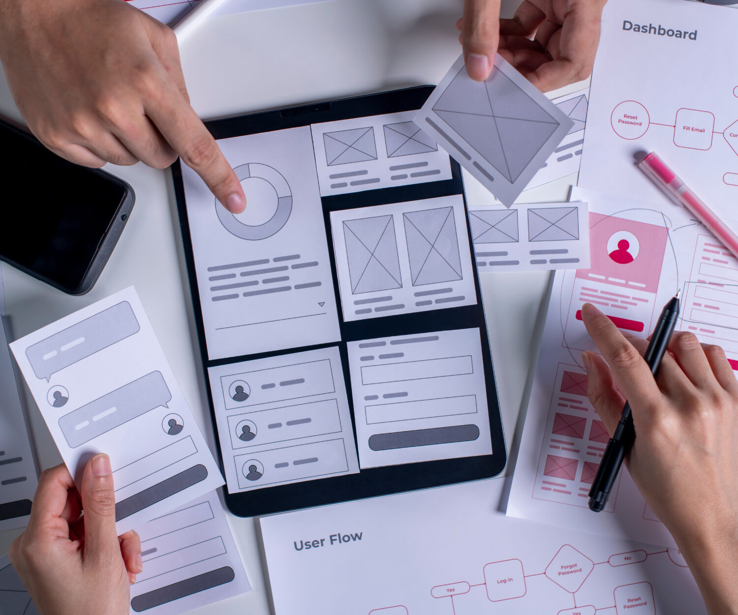 Close up ux developer and ui designer brainstorming about mobile app interface wireframe design on table.