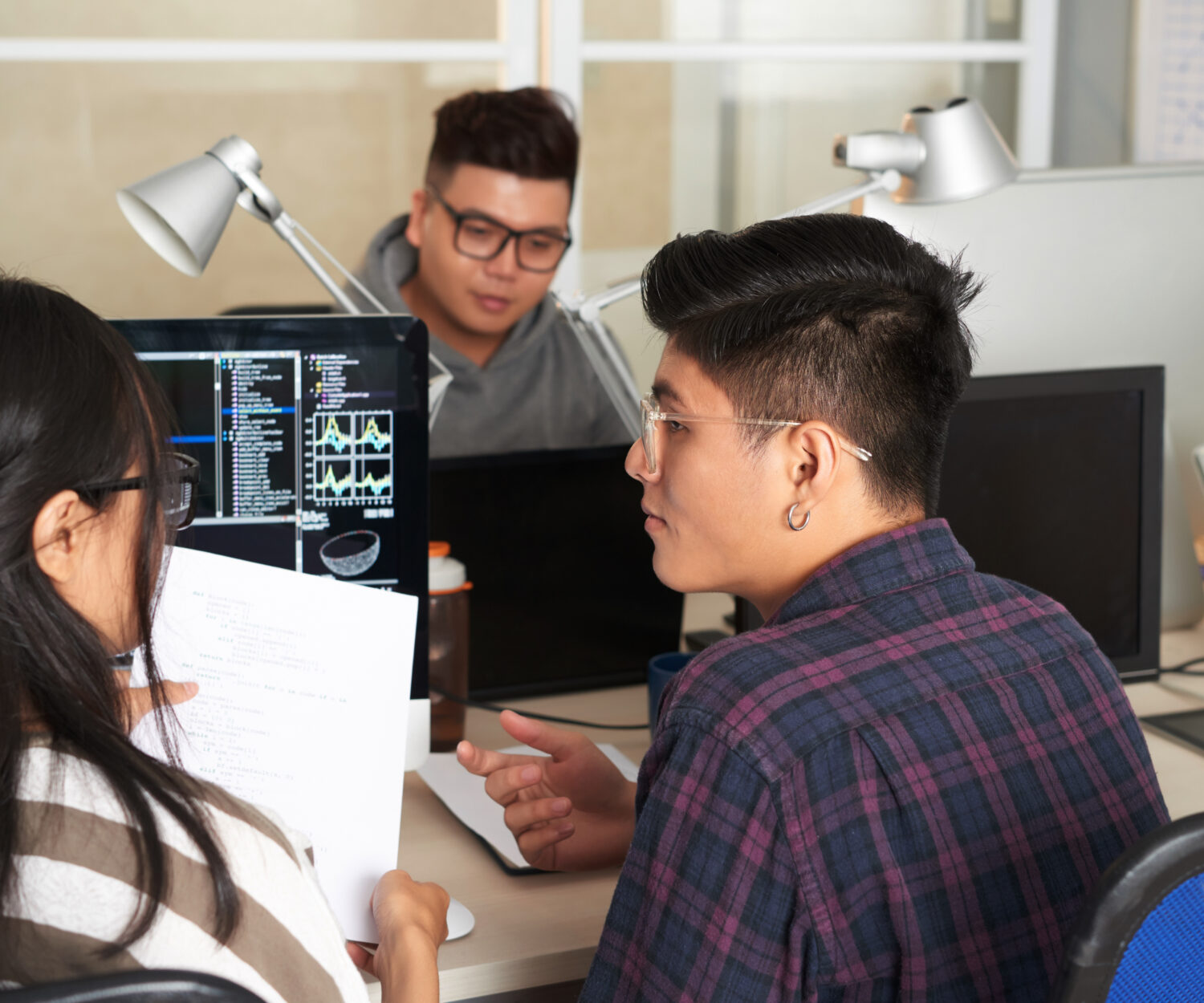College students discussing programming code at class of computer science when working on project together
