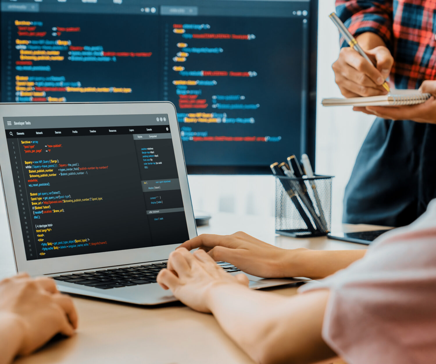 Two smart cooperative computer engineers working together as teamwork to solve program code while computer screen displayed program code. Laptop, web development, programer, java script . Burgeoning.